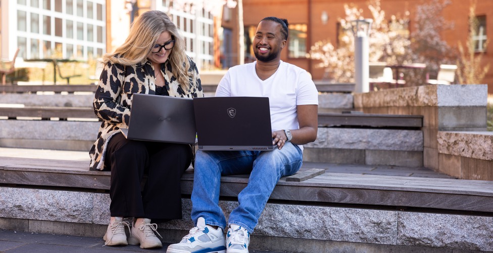 Glada studenter på campus