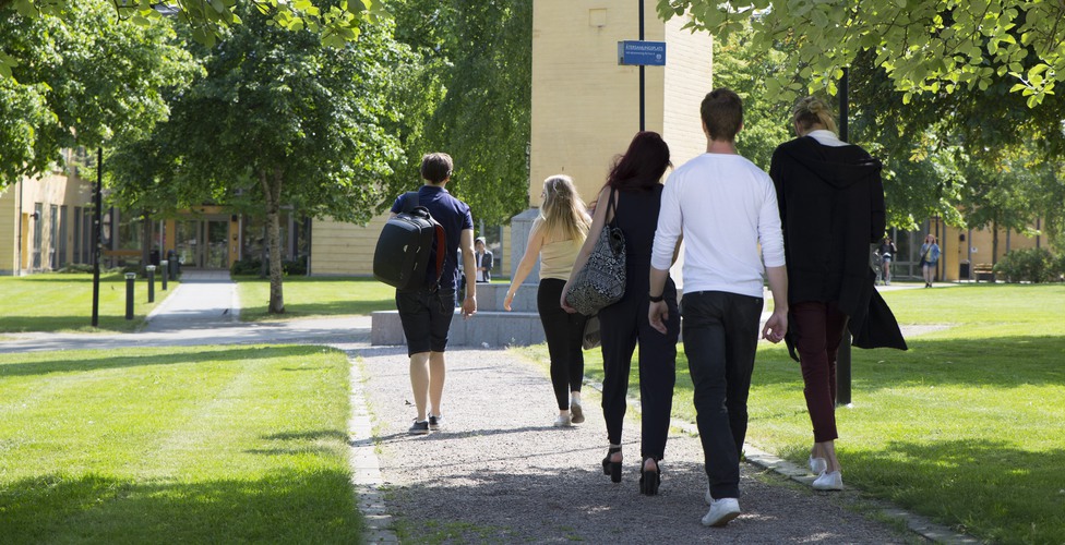 Studentgrupp rör sig över campusområdet. Mellan göta och G