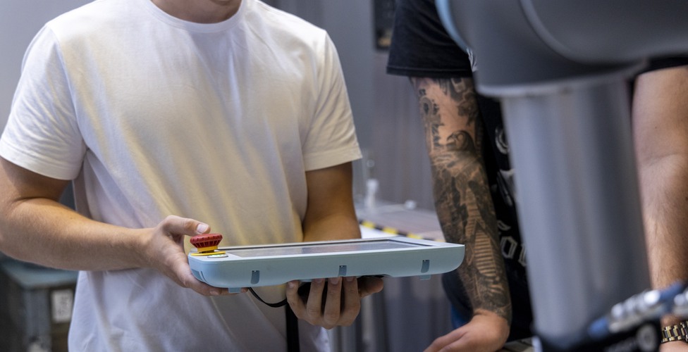 Person håller i en handhållen enhet.