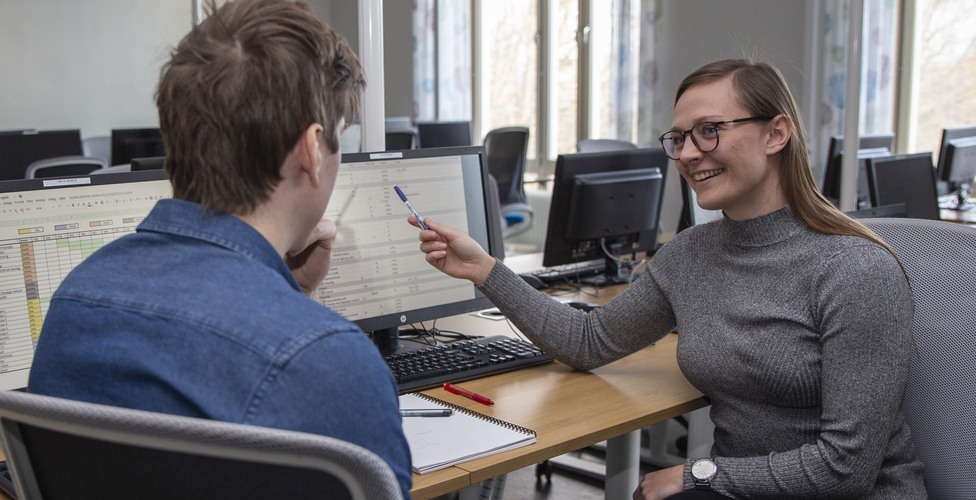 Studenter arbetar tillsammans i datorsal på campus