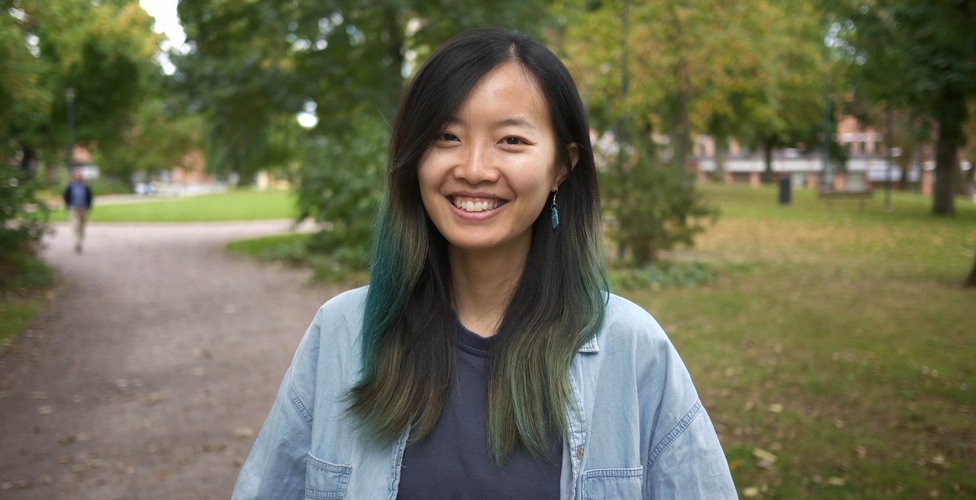 Wu Mingmin står utomhus i en parkmiljö