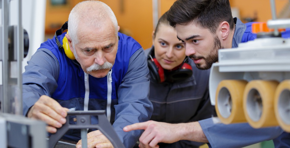 En person demonstrerar hur ett arbete fungerar för två andra personer.